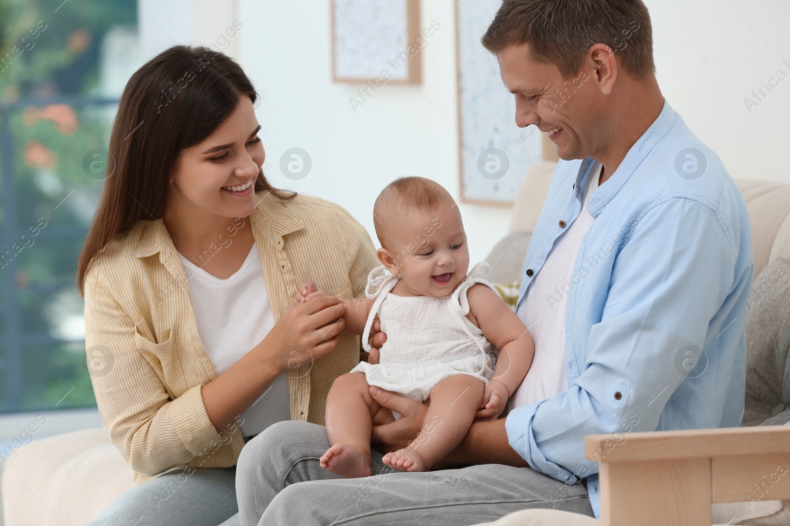 Photo of Portrait of happy family with their cute baby at home