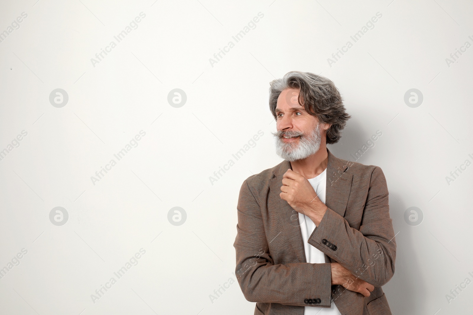 Photo of Portrait of handsome mature man on light background. Space for text