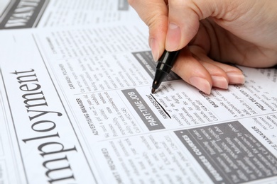 Woman marking advertisement in newspaper, closeup. Job search concept