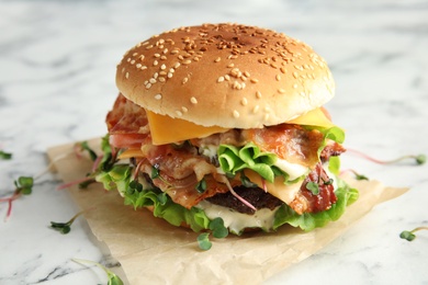 Tasty burger with bacon on marble table