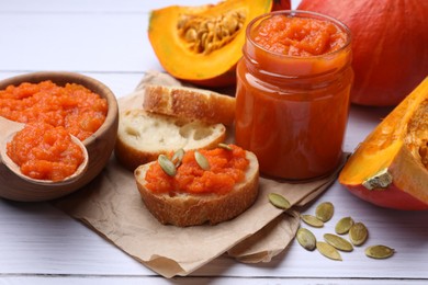 Delicious pumpkin jam and fresh pumpkins on white wooden table