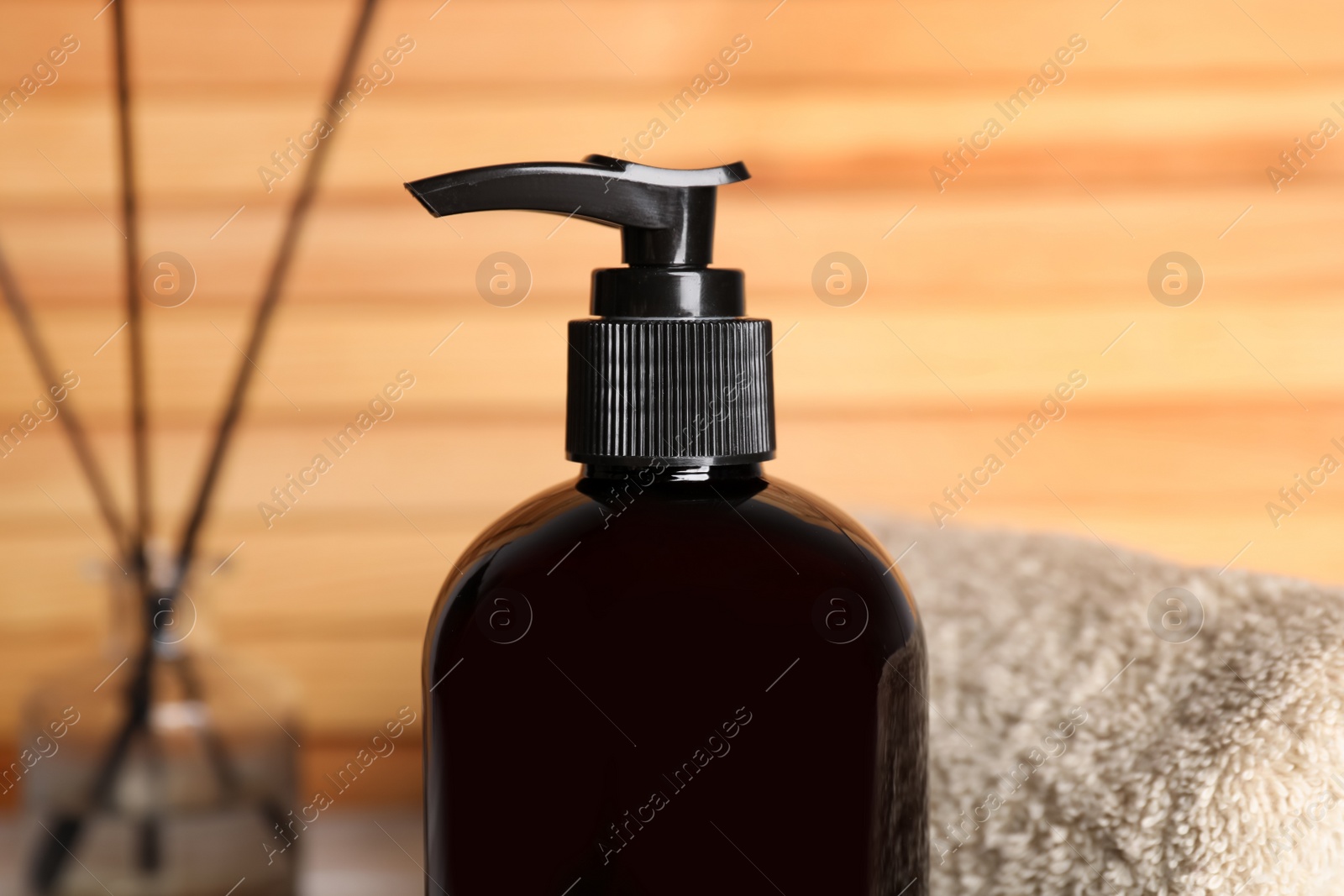 Photo of Bottle of shampoo on blurred background, closeup