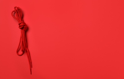 Photo of Shoelaces on red background, top view. Space for text