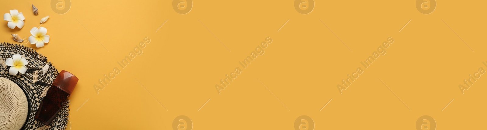 Photo of Sun protection cream and beach accessories on orange background, flat lay. Space for text