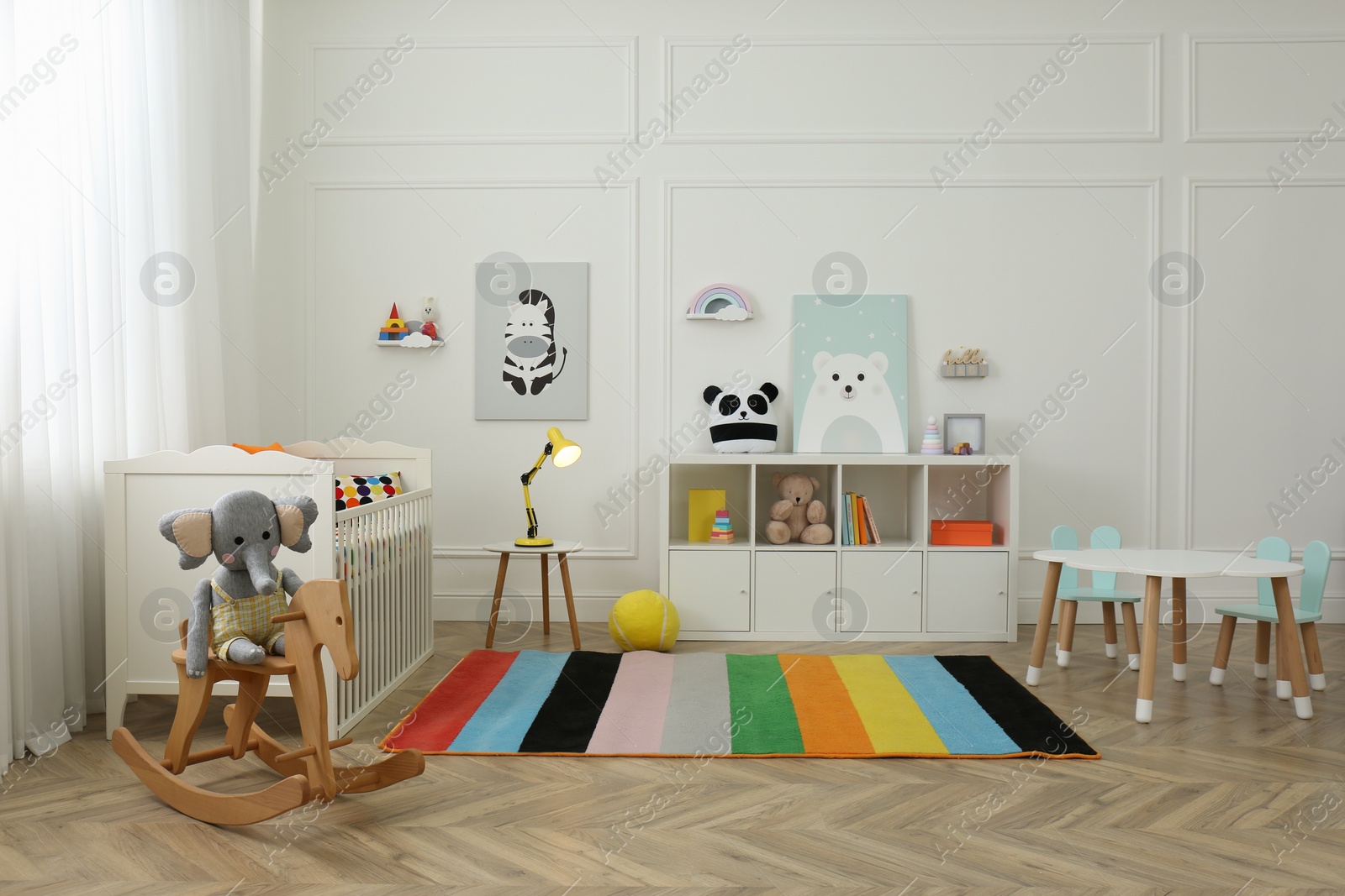 Photo of Cute baby room interior with stylish furniture and toys