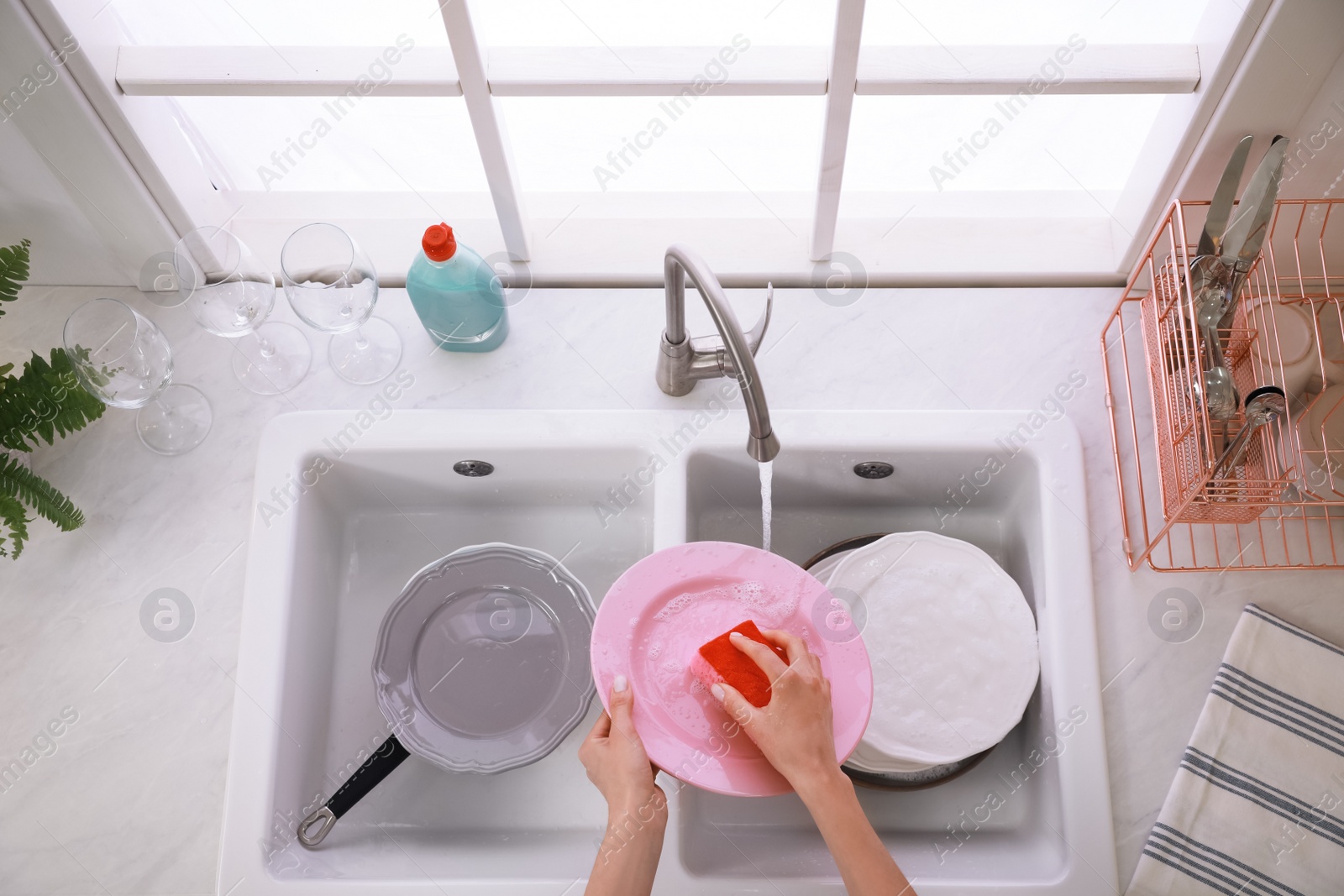 Photo of Woman washing plate above sink in kitchen, closeup