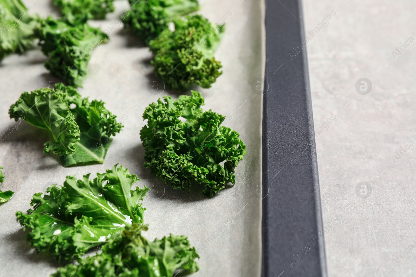 Photo of Raw cabbage leaves on grey table, closeup. Preparing kale chips