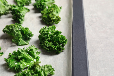 Raw cabbage leaves on grey table, closeup. Preparing kale chips