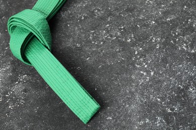 Photo of Green karate belt on gray textured background, space for text