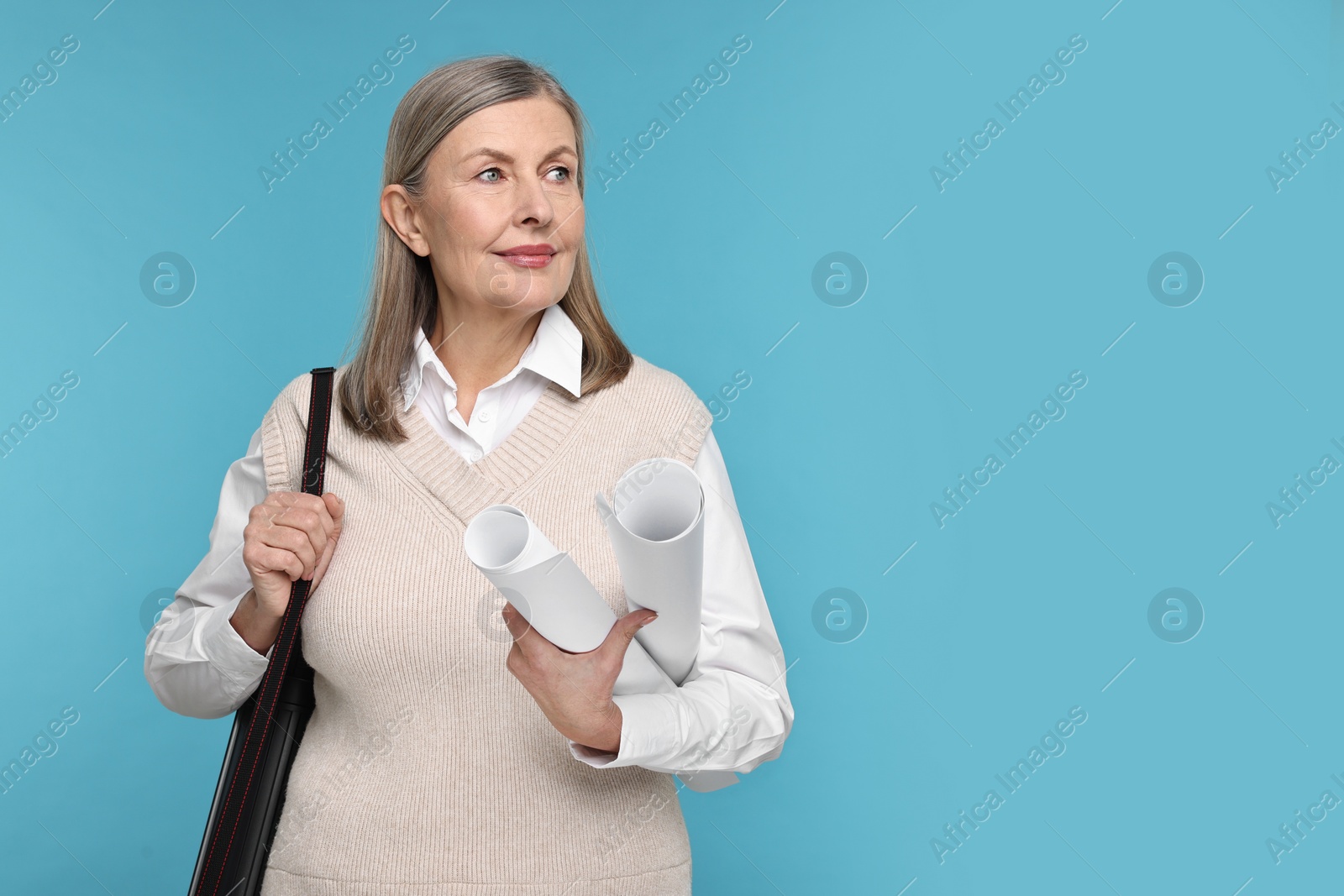 Photo of Architect with drafts and tube on light blue background, space for text