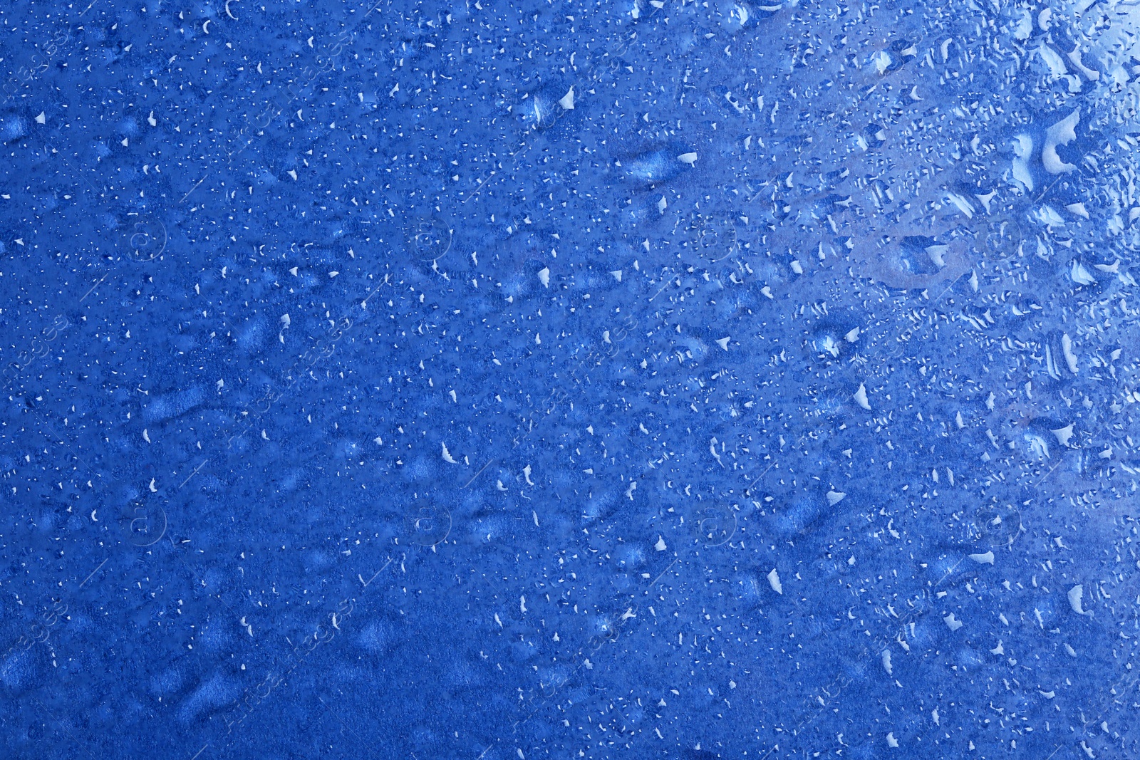 Photo of Water drops on color background, top view