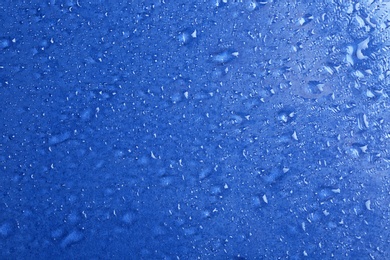 Photo of Water drops on color background, top view