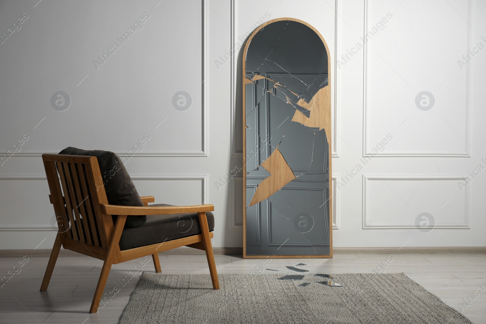 Photo of Broken mirror with many cracks and armchair in room