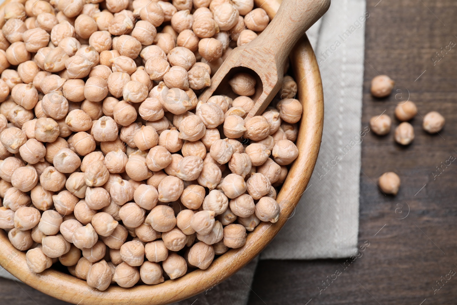 Photo of Chickpeas in bowl on wooden table, flat lay