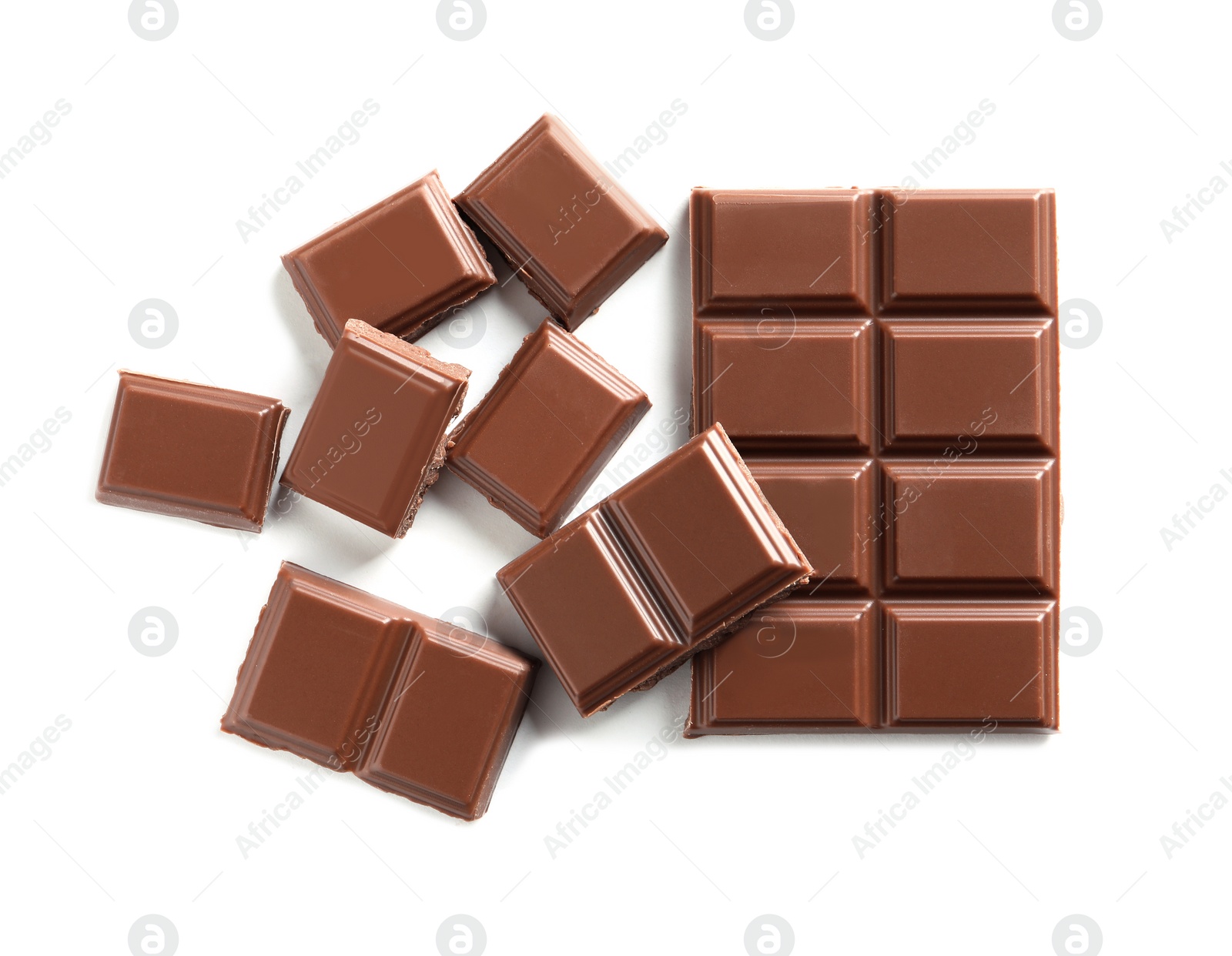 Photo of Pieces of tasty milk chocolate on white background, top view