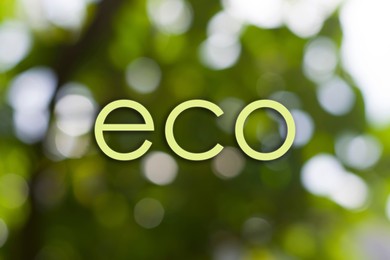 Image of Word ECO on blurred green background. Bokeh effect