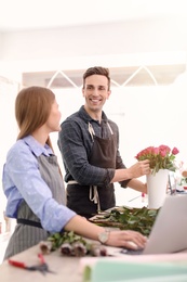 Male and female florists working in flower shop