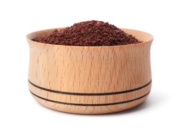 Photo of Wooden bowl with sumac on white background. Different spices