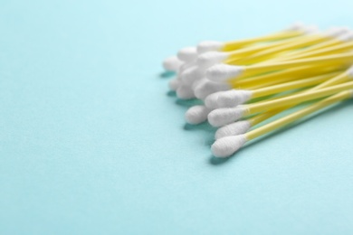 Photo of Pile of cotton swabs and space for text on color background