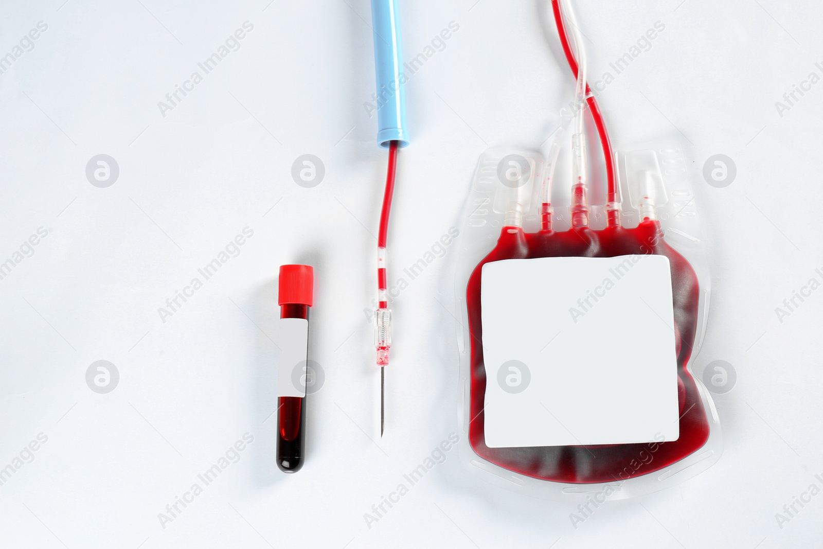 Photo of Blood pack for transfusion and test tube on white background, top view. Donation day