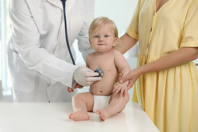 Pediatrician examining baby with stethoscope in hospital. Health care