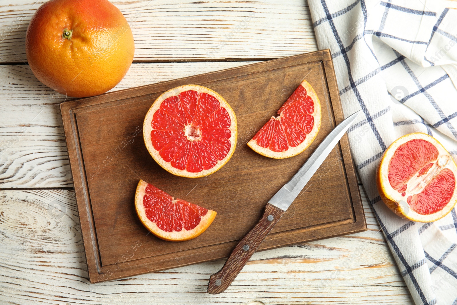 Photo of Flat lay composition with grapefruits, board and knife on wooden background