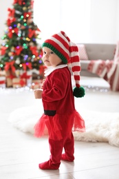 Photo of Cute baby in Christmas costume at home