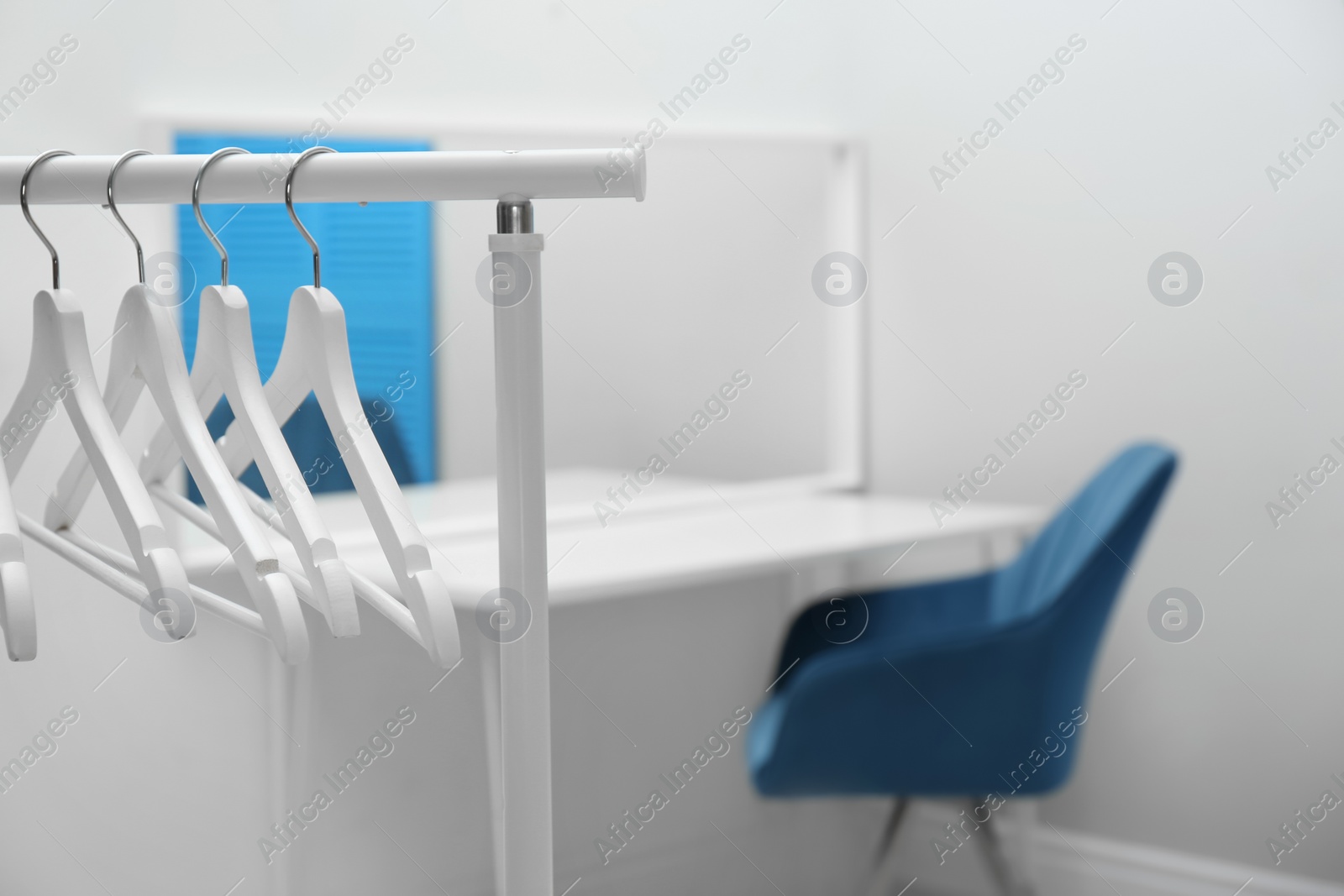 Photo of Wardrobe rack with clothes hangers in dressing room