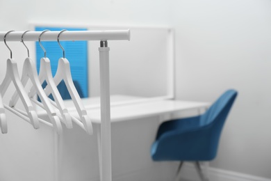 Photo of Wardrobe rack with clothes hangers in dressing room