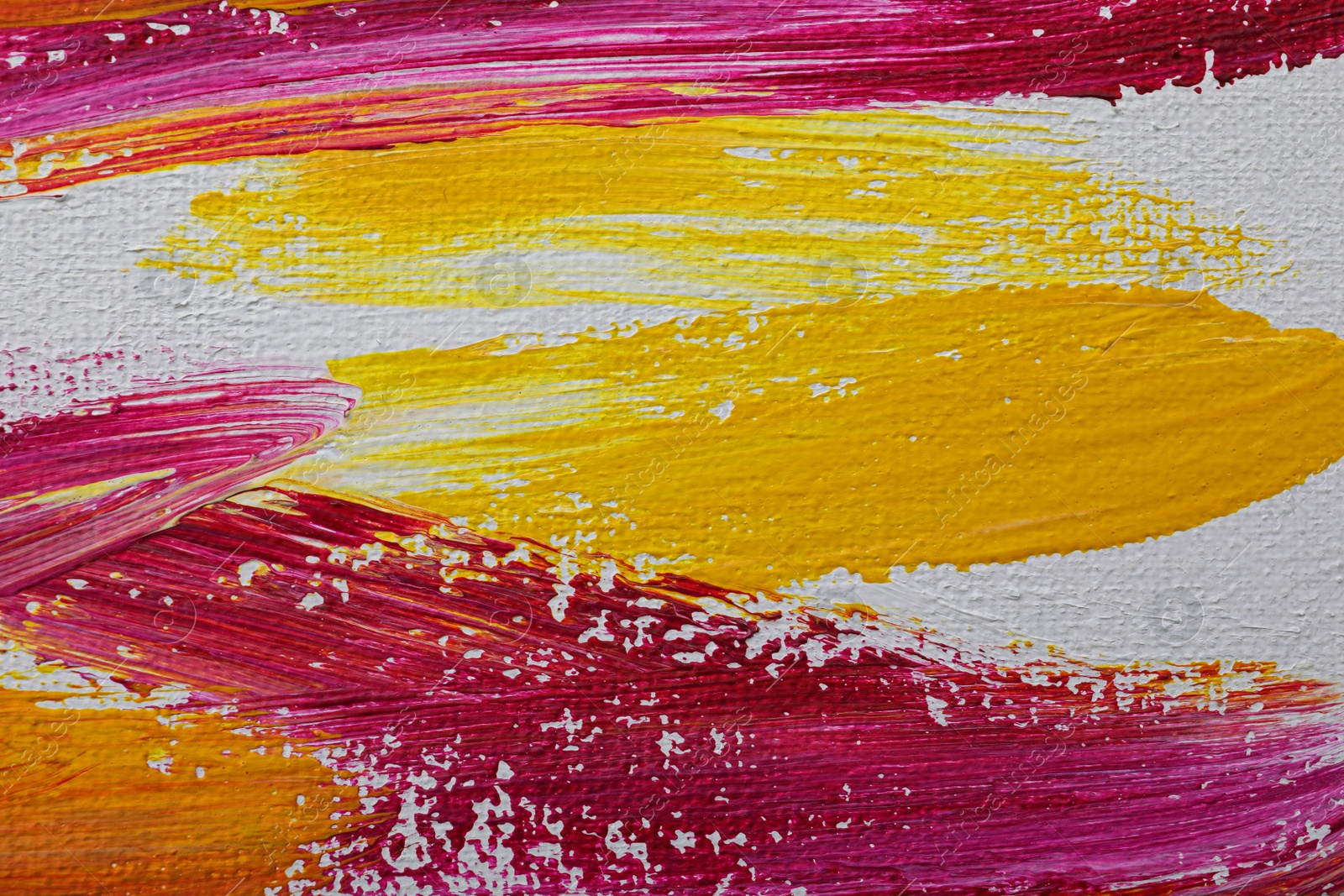 Photo of Strokes of colorful oil paints on white canvas, closeup