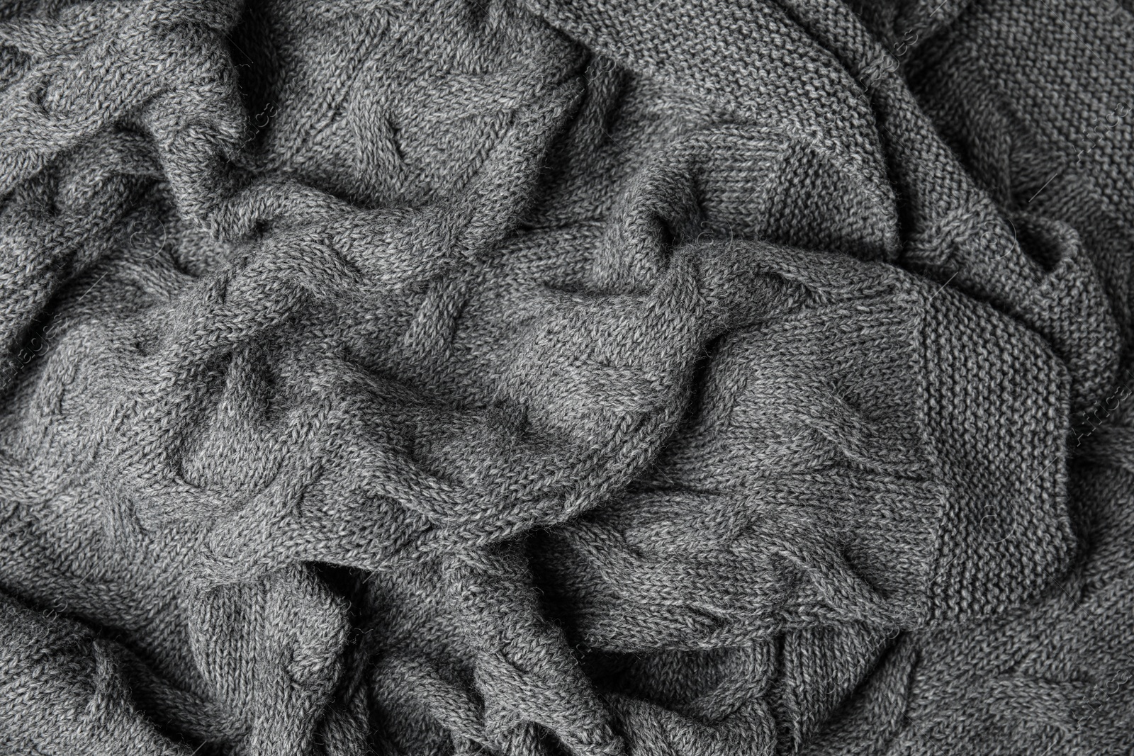 Photo of Soft grey knitted plaid as background, top view