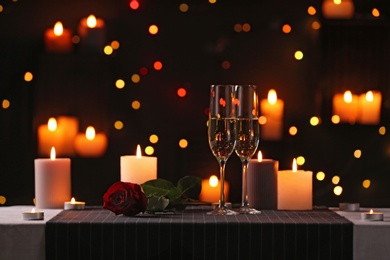 Photo of Romantic dinner table setting with burning candles and festive lights