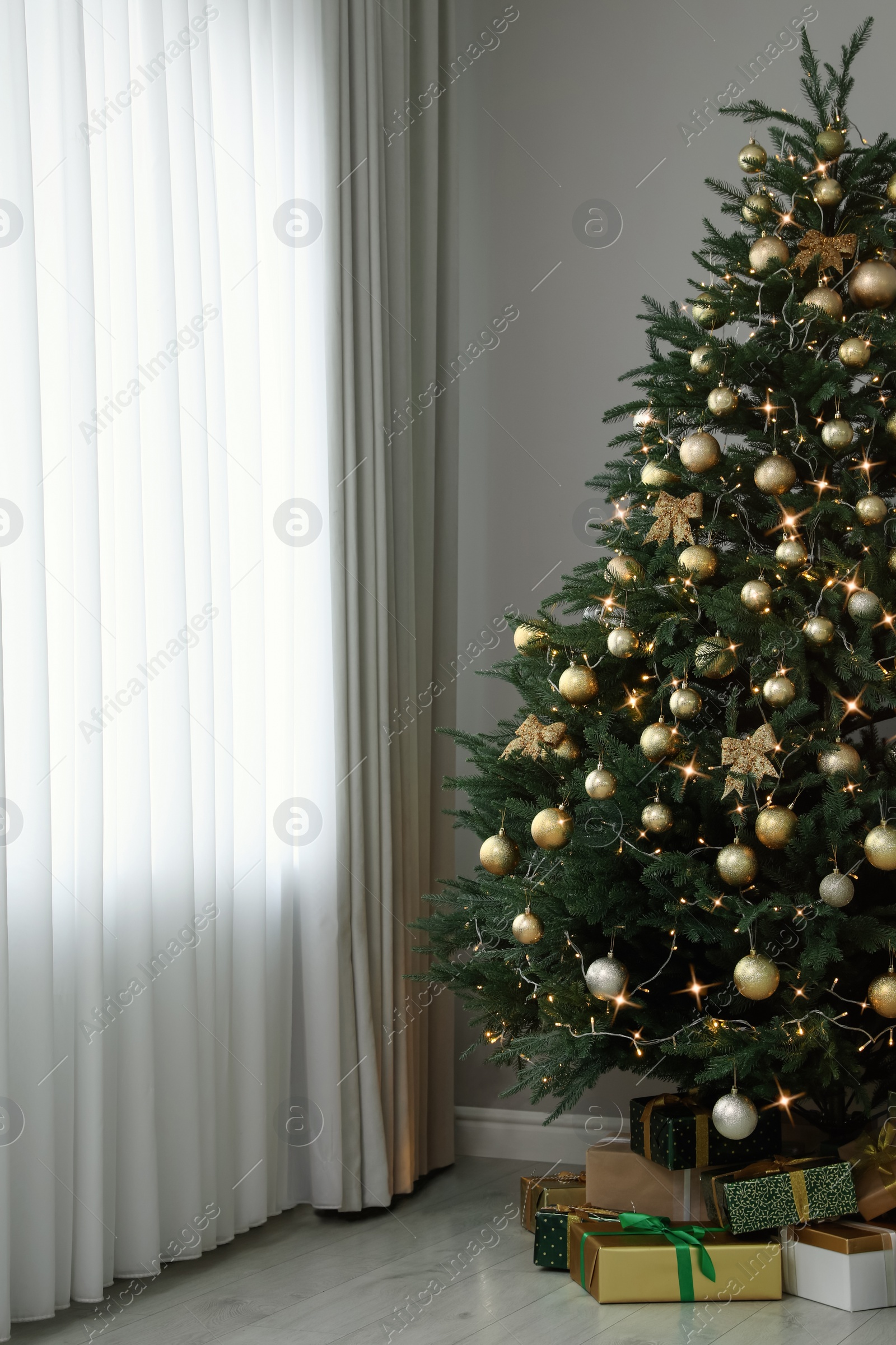 Photo of Beautifully decorated Christmas tree and gifts indoors