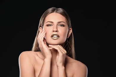 Portrait of beautiful lady with gold lipstick on black background