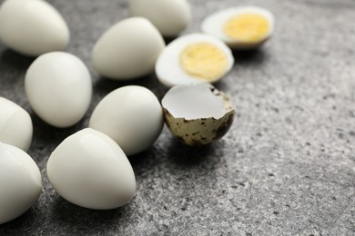 Photo of Peeled hard boiled quail eggs on grey table, closeup