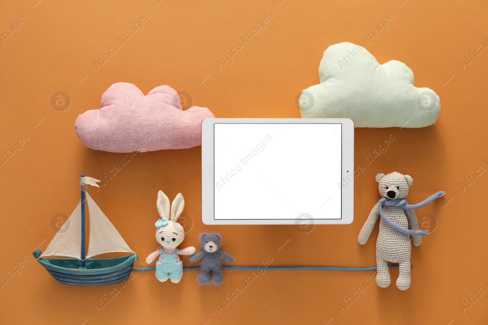 Photo of Modern tablet and toys on brown background, flat lay. Space for text