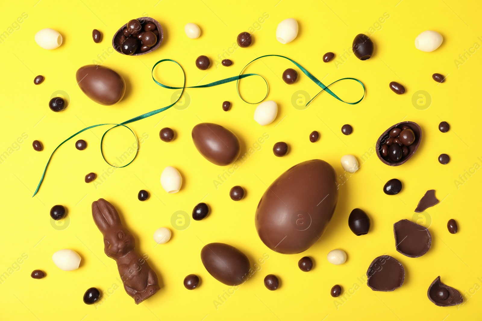 Photo of Flat lay composition with chocolate Easter eggs on color background