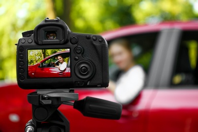 Photo of Photography of young woman in car, focus on camera. Space for text