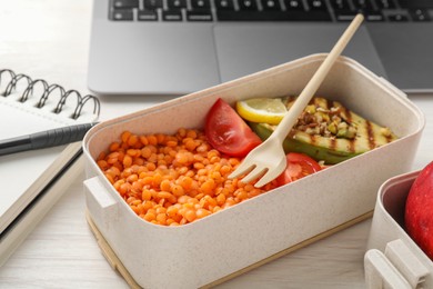 Photo of Healthy products high in vegetable fats near laptop on light wooden table, closeup