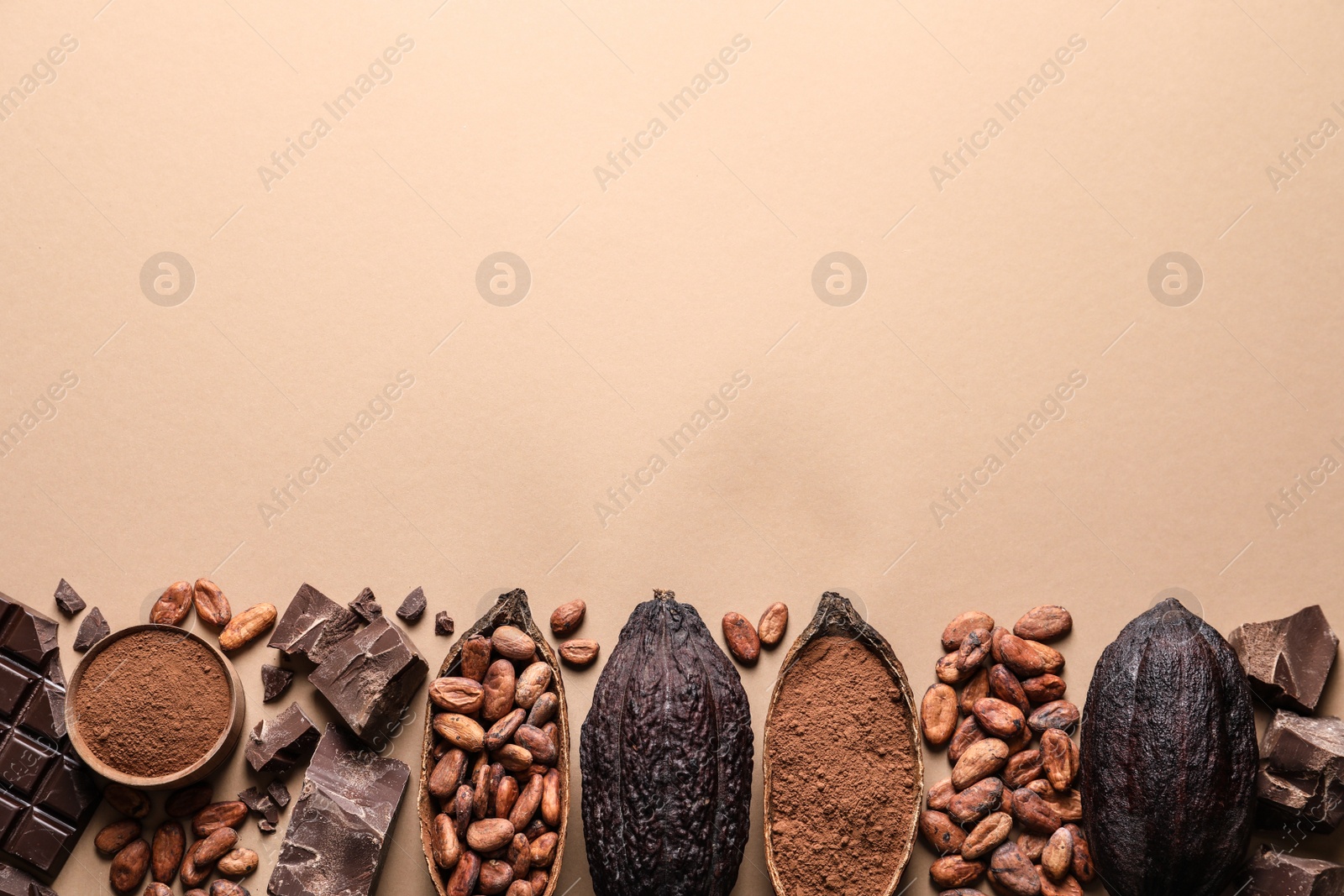 Photo of Flat lay composition with cocoa pods and chocolate on beige background, space for text