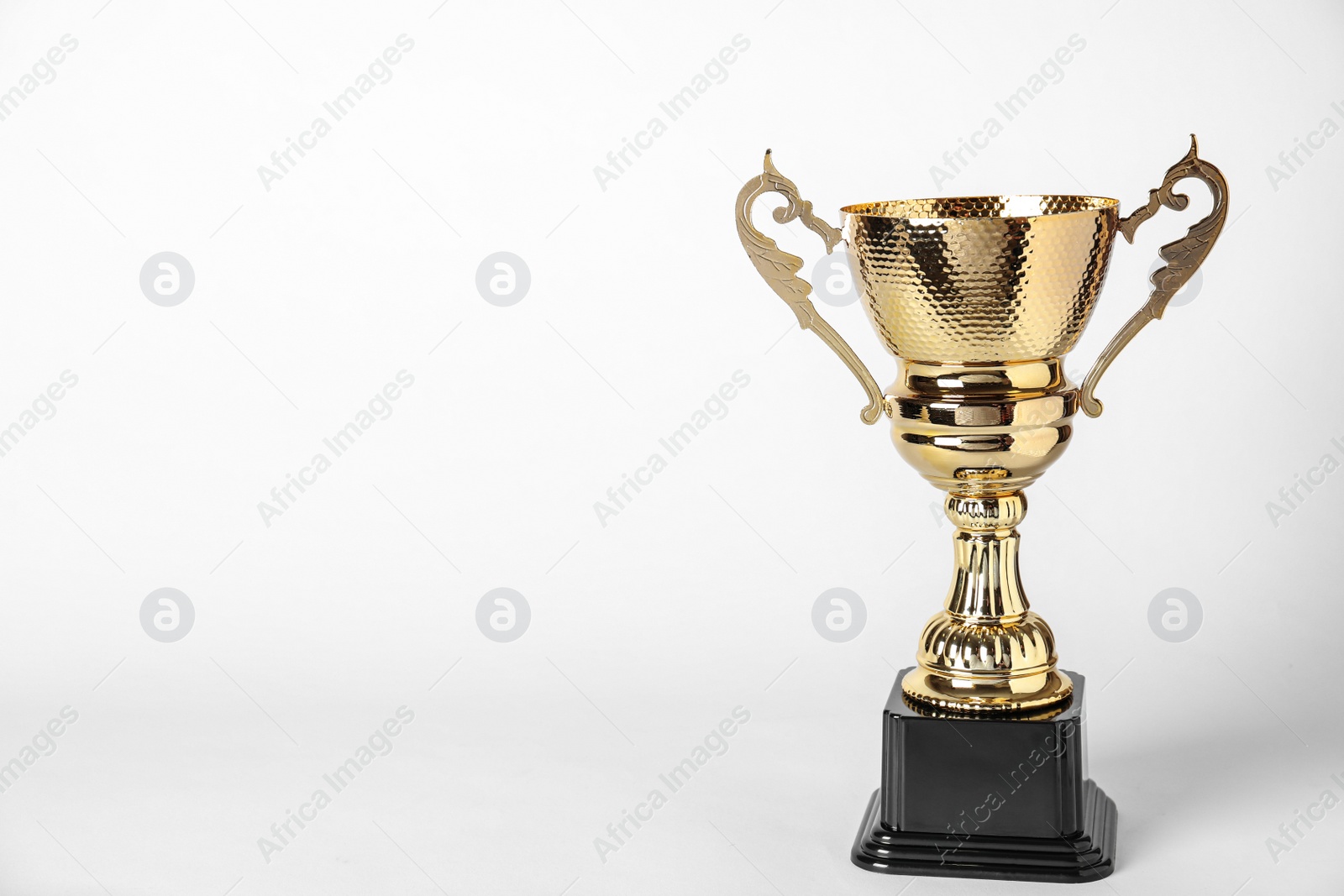 Photo of Shiny golden trophy cup on white background