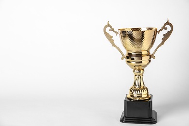 Shiny golden trophy cup on white background