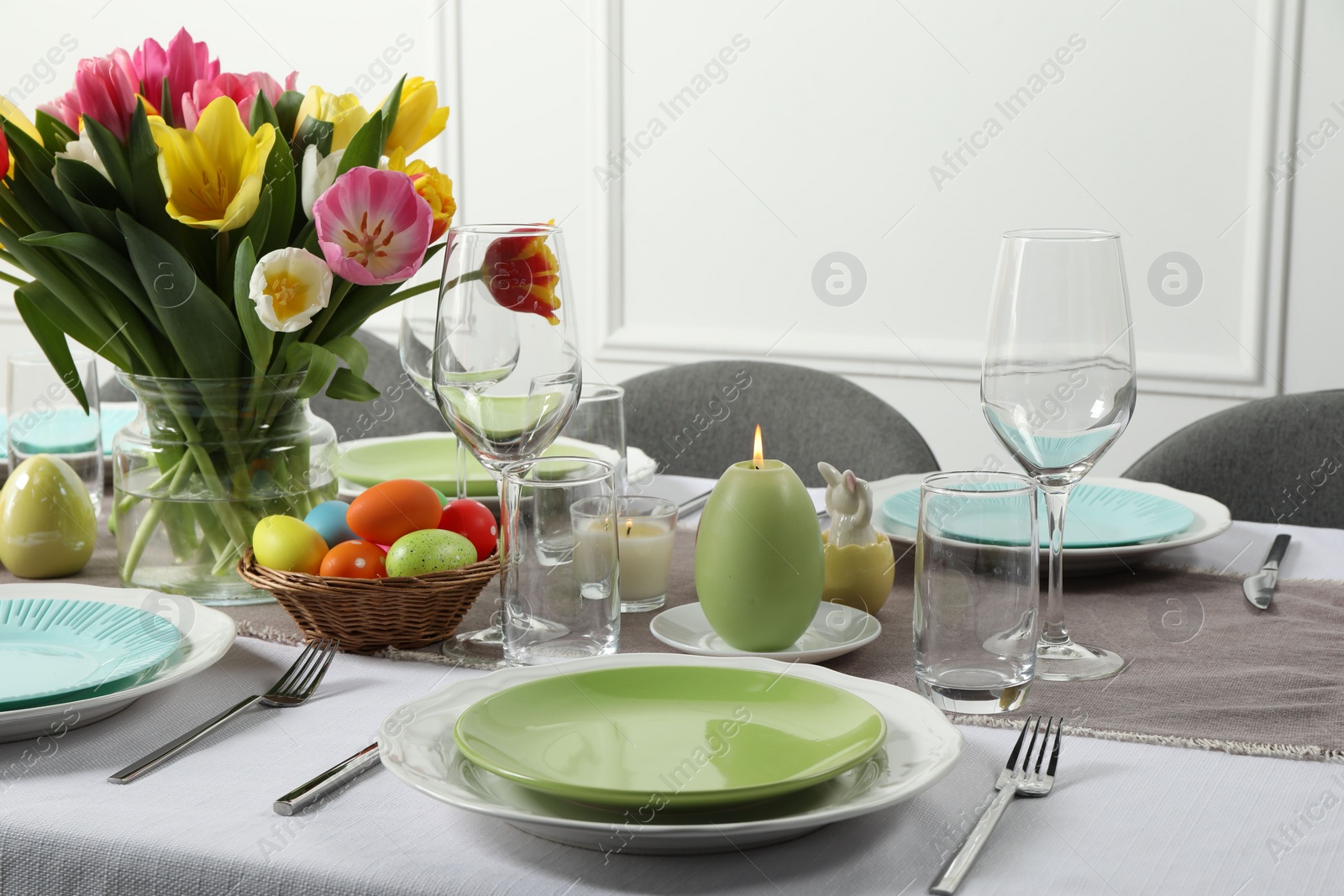 Photo of Easter celebration. Festive table setting with beautiful flowers and painted eggs