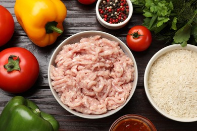 Photo of Making stuffed peppers. Ground meat and other ingredients on wooden table, flat lay