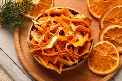 Photo of Dry orange peels and slices on cloth, flat lay