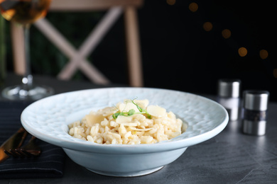 Delicious risotto with cheese on grey table