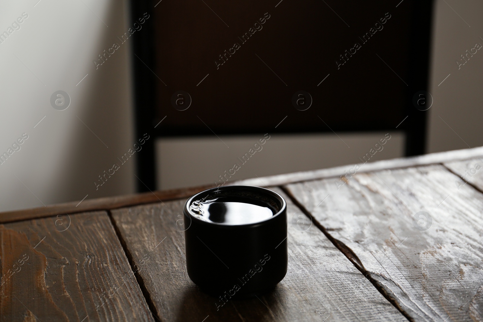 Photo of Cup of aromatic coffee on wooden table in cafe. Space for text