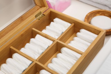Photo of Storage of tampons and different hygiene products in white drawer, closeup