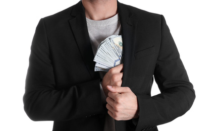 Man putting bribe money into pocket on white background, closeup