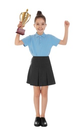 Photo of Happy girl in school uniform with golden winning cup isolated on white